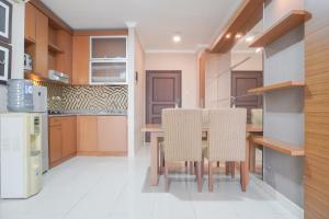 ジャカルタにあるComfort and Simply Look 1BR at Bellezza Apartment By Travelioの木製のテーブルと椅子のあるキッチン