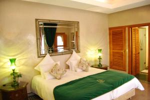 Schlafzimmer mit einem Bett und einem Spiegel an der Wand in der Unterkunft Riad Flam & Spa in Marrakesch