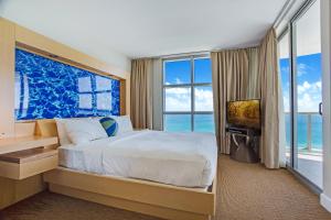 マイアミビーチにあるMarenas Beach Resort Private Luxury Suitesのベッドと大きな窓のある寝室 +108枚の写真