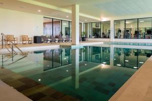 a swimming pool in a house with glass walls at Royal Green Wellness Resort in Moka