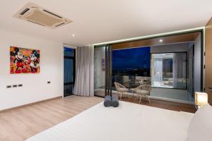 a bedroom with a large bed and a dining room at Villa Serenity Bay, Modern 4-BR Partial Sea View villa in Plai Laem