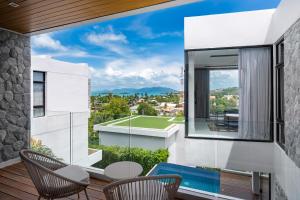 a balcony with a view of a house at Villa Serenity Bay, Modern 4-BR Partial Sea View villa in Plai Laem