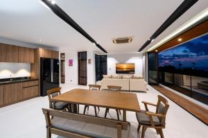 a living room with a table and chairs and a couch at Villa Serenity Bay, Modern 4-BR Partial Sea View villa in Plai Laem +11 photos