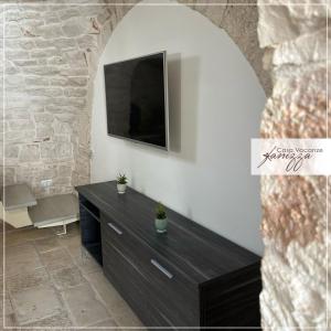 Una sala de estar con un televisor en la pared. en Trullo Diaz Fanizza, en Alberobello