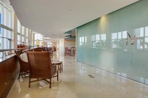 einen Flur mit Stühlen und einer Glaswand in der Unterkunft Marenas Beach Resort Private Luxury Suites in Miami Beach