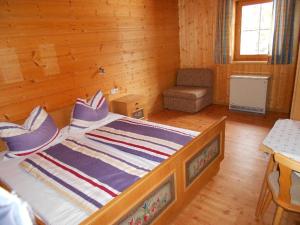 - une chambre avec un lit et une chaise dans l'établissement Ferienwohnung Trattenhaus, à Krimml