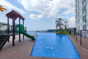 un parque infantil en medio de una piscina en Comfortable and Modern 1BR without Living Room at Amartha View Apartment By Travelio, en Semarang