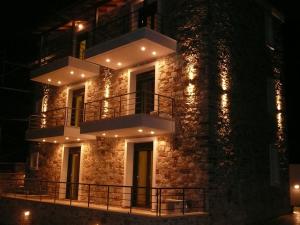 a large brick building with a balcony at night at Labetia Apartments in Agioi Apostoli