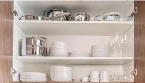 a cabinet filled with dishes and pots and pans at Superbe Studio en Plein Centre à Lausanne Gare in Lausanne +6 photos