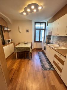 a kitchen with a table and a sink in it at La Casetta dei Sognatori tra Santa Caterina e Bormio in Valfurva