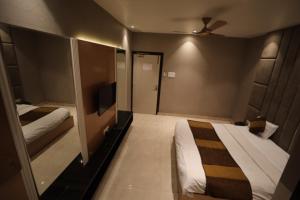 a hotel room with a bed and a tv at Hotel Maya crystal in Juhi Bari