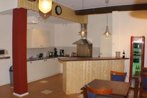 eine Küche mit einer Theke, einem Tisch und Stühlen in der Unterkunft Erve Höwerboer in Ootmarsum