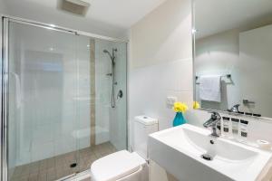 a bathroom with a shower and a sink and a toilet at Oaks Ipswich Aspire Suites in Ipswich
