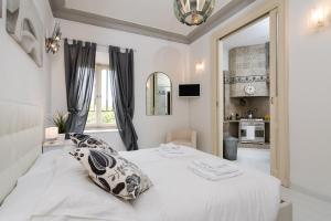un letto bianco in una stanza con finestra di White Borgo Apartment a Roma