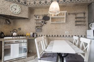 ローマにあるWhite Borgo Apartmentのキッチン(テーブル、壁掛け時計付)