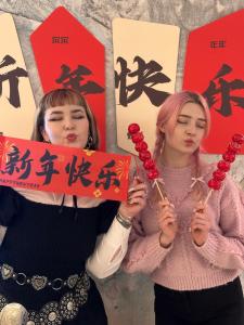 two women holding umbrellas with writing on them at Hi Cozy International Youth Hostel East Nanjing Road & The Bund - Free Gym in Shanghai