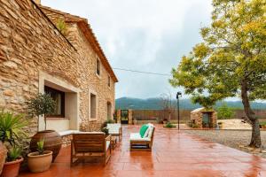 an outdoor patio with chairs and a building at Mas de Morera in Vall dʼAlba