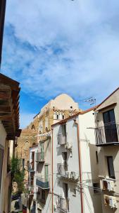 a building with balconies and a building with a dome at Da Nenè in Cefalù