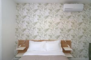 una camera da letto con un letto con carta da parati floreale di Benedetta suite in florence a Firenze