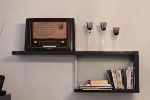 een tv op een plank met wijnglazen en boeken bij Feel at Home 2 in Heidelberg