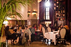 a group of people sitting at tables in a restaurant at The Culver Hotel in Los Angeles