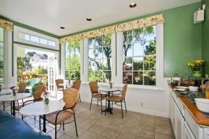 una cocina con mesas, sillas y ventanas en Parker Guest House, en San Francisco