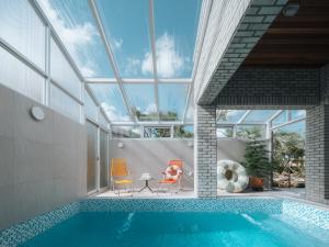 an indoor swimming pool with a glass ceiling at Better than good in Jeju