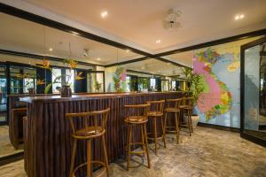 a bar with wooden stools at a bar with a map on the wall at Hoian Beachfront Homestay in Tân Thành (1)