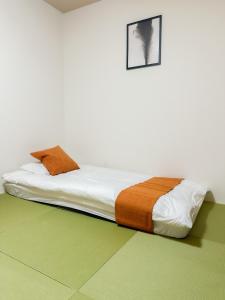a bed in a white room with avertisement for at HANASTAY花渓居 · 海（UMI) in Osaka