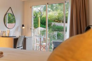 a room with a large window and a table and chairs at Minura Cala Galdana & Apartamentos d'Aljandar in Cala Galdana