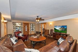una sala de estar con un sofá y una mesa en Big 10 Luxury Cabin/Walk to Snow Summit- HotTub, en Big Bear Lake