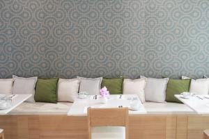 una mesa con mesas y sillas blancas y una pared en P21 Chiangmai Hotel, en Chiang Mai