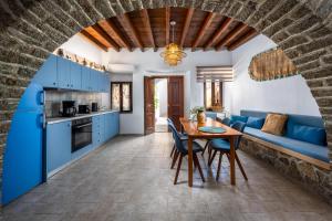 a kitchen and living room with blue cabinets and a table at Aelius Apartments in Symi +31 photos