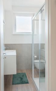 ein Badezimmer mit Toilette und Waschbecken und einem Fenster in der Unterkunft Duplex Lakeside Penthouse in Porto Valtravaglia
