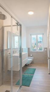 ein Badezimmer mit Badewanne, Waschbecken und Toilette in der Unterkunft Duplex Lakeside Penthouse in Porto Valtravaglia