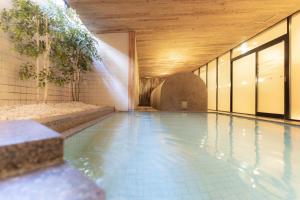ein Schwimmbad in einem Gebäude mit Holzdecke in der Unterkunft Authent Hotel Otaru in Otaru
