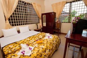 Un dormitorio con una cama con flores. en Okay Guesthouse Siem Reap, en Siem Reap