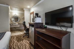 um quarto de hotel com uma grande televisão de ecrã plano em Americas Best Value Inn Richmond em Richmond