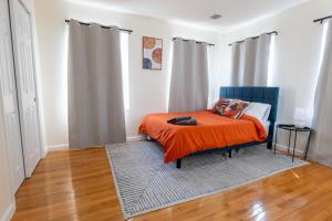 a bedroom with a bed with an orange blanket at New 4 Apts-198-3 Bed Apt 1st Floor & 3 Bed Apt 2nd Floor - 1 Bed Studio Apt Ground Floor & 1 Bed Studio Apt Ground Floor near Penn Station EWR Airport Hospital NYC in Newark