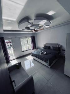 Un dormitorio con una cama y un ventilador de techo. en Hotel Paradise Palm, en Rishīkesh