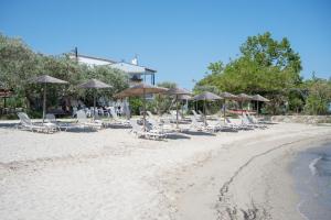 a group of chairs and umbrellas on a beach at Aegean Sun Hotel in Skala Rachoniou