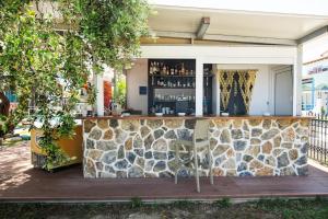 an outdoor bar with a stone wall at Aegean Sun Hotel in Skala Rachoniou