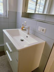 a bathroom with a white sink and a mirror at Moderne City Wohnung - stylisch und schick mit 2 Schlafzimmern auf 100qm in Schwäbisch Hall +7 photos