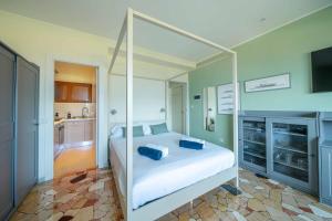 Il Nido Belmonte - Lakeview في Brezzo: غرفة نوم مع سرير أبيض كبير مع مظلة