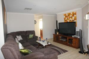 a living room with a couch and a flat screen tv at Mimi's House in Perth
