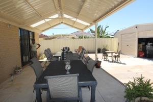 um pátio com uma mesa, cadeiras e toldo em Mimi's House em Perth