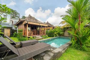 a villa with a swimming pool and a house at Villa Kayu By Mardika in Ubud