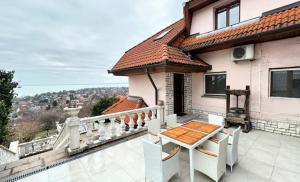 a balcony of a house with a table and a view at Villa Kamilla in Balatongyörök