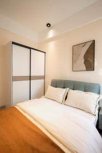 a bedroom with a large bed with white sheets at Luxury 1-Bedroom Apartment in Kigali