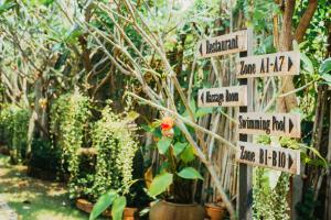 a garden with signs pointing in different directions at Pai Sukhothai Resort SHA Extra Plus in Sukhothai